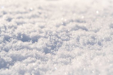 Macro gün batımında taze beyaz karın arka planını çekti. Kar taneleri dokusu. Kar dokusu kış arka planı. Bokeh güneş ışınlı parlak kar.