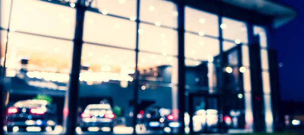 Blurred background with car dealership exterior. Abstract blurred photo of modern building motor showroom. Blur car show room office bokeh lights. Automobile retail shop