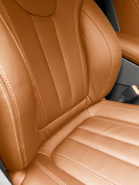 Modern lüks turuncu, kırmızı deri iç döşeme. Kırmızı deri koltuğun dikişli bir parçası. Prestij arabasının içi. Rahat kahverengi deri koltuklar. Delinmiş deri..