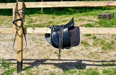 saddle from a horse hanging on a fence