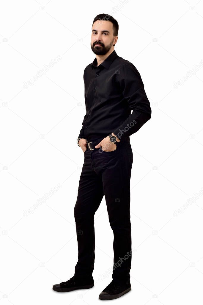  man with a beard in black clothes holds his hands in his pants pockets
