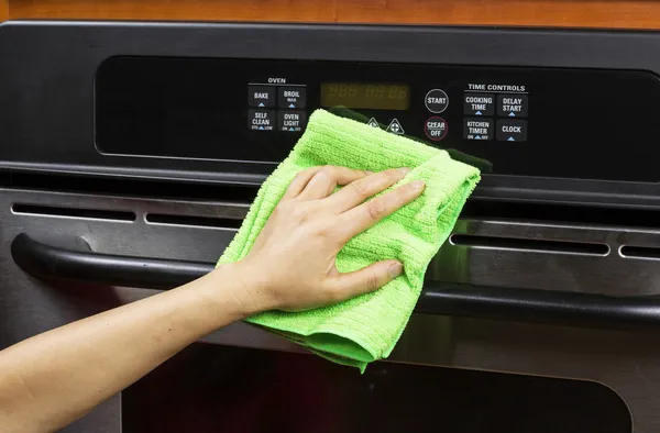 Cleaning kitchen appliance display and vents on electric oven — Stock Photo, Image