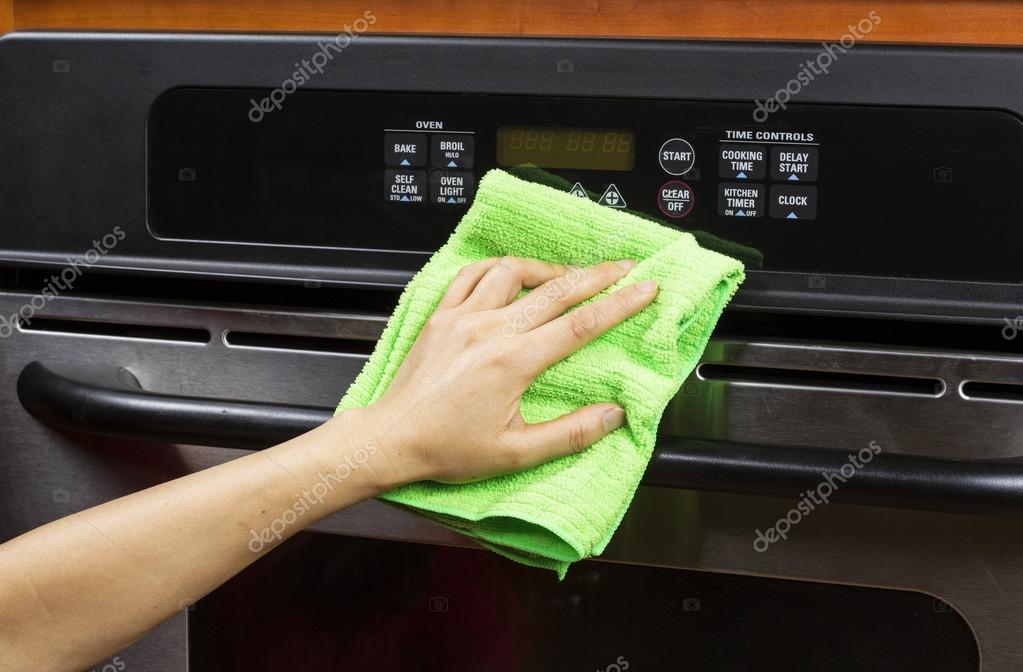 Cleaning kitchen appliance display and vents on electric oven — Stock Photo © tab62 16933161