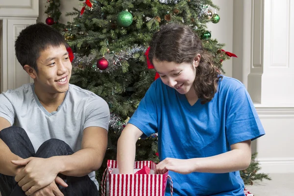 Hermano y hermana disfrutando de compartir regalos el día de Navidad — Foto de Stock