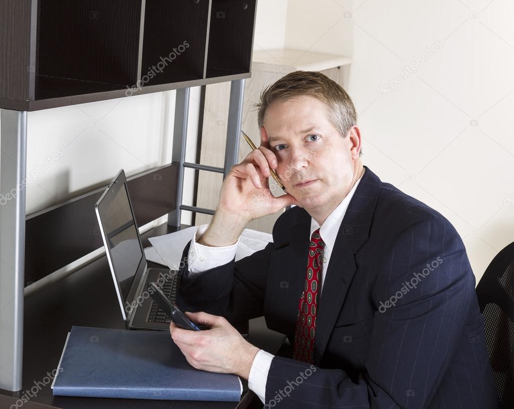 Mature Man in thought while doing personal income taxes