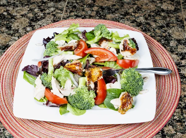 Salat auf weißem Teller mit Unterlage — Stockfoto