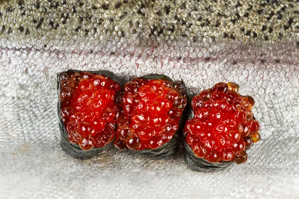 Huevos de salmón rojo en la parte superior de la piel de salmón — Foto de Stock