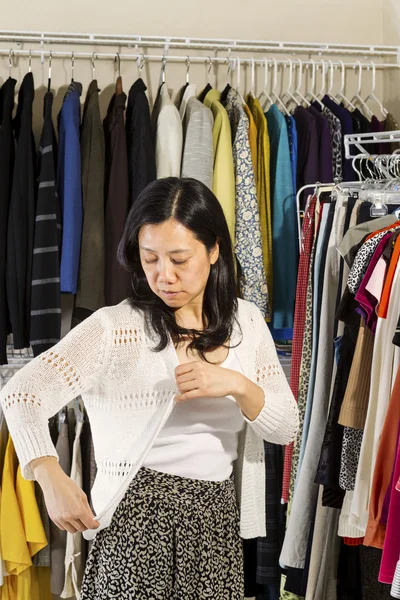 Mujer madura inspeccionando su suéter —  Fotos de Stock