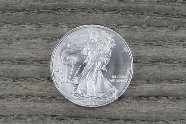 Soluk tahta üzerinde saf gümüş dolar — Stok fotoğraf