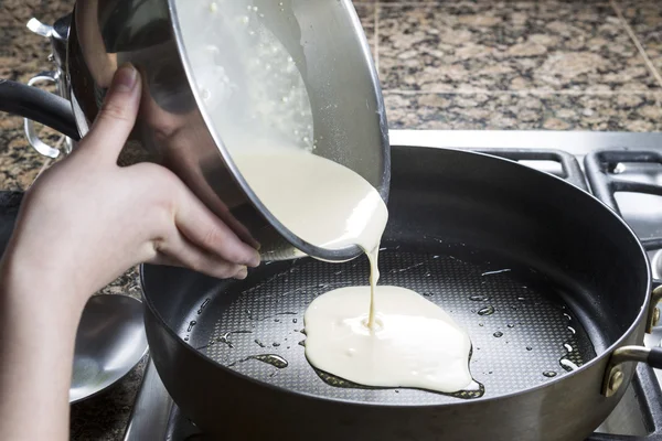 Despejando panqueca misturar em frigideira quente — Fotografia de Stock