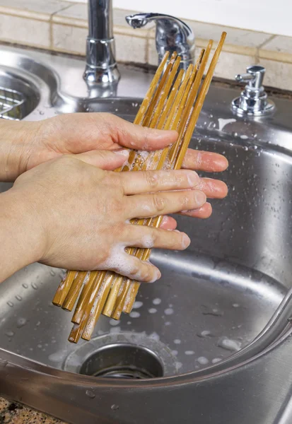 Female hands soaping up chopsticks — Stock Photo, Image