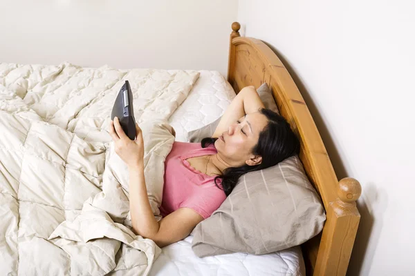 Mulher madura olhando para o despertador enquanto tenta dormir — Fotografia de Stock