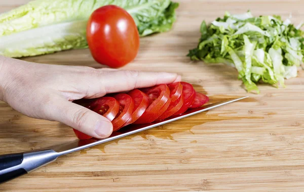Нарезание помидоров для салата — стоковое фото