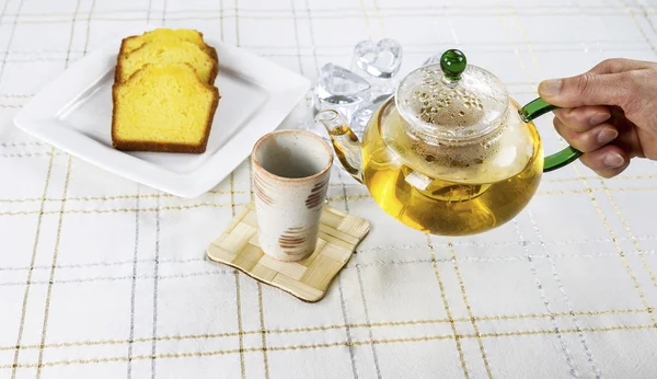 Preparación de la mano para verter té verde en la taza —  Fotos de Stock