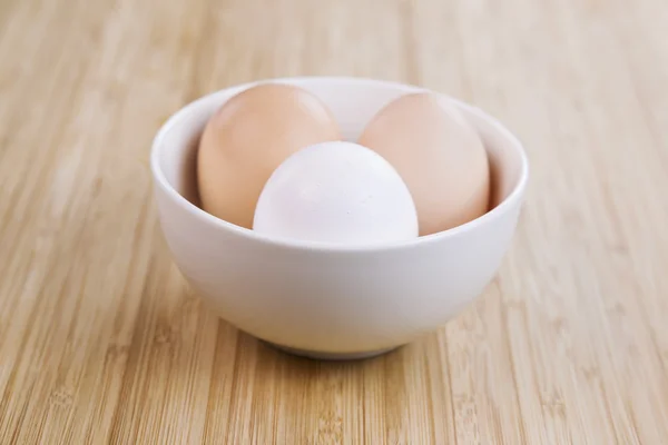 Целые органические яйца в белой чаше — стоковое фото