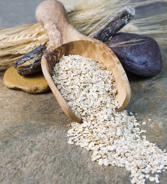 Cereale de ovăz uscat în lingură de lemn pe setarea pietrei — Fotografie, imagine de stoc