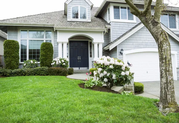 Wohnhaus mitten im Frühling mit blühenden Blumen und — Stockfoto