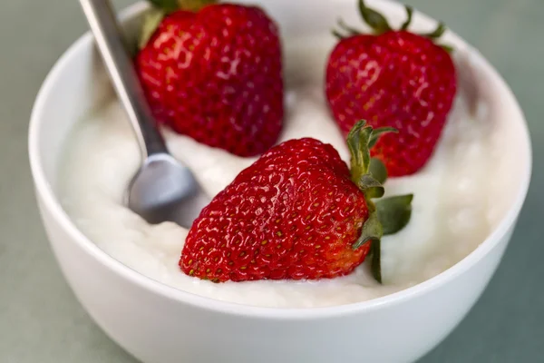 整个草莓香草酸奶中用勺子在碗里 — 图库照片