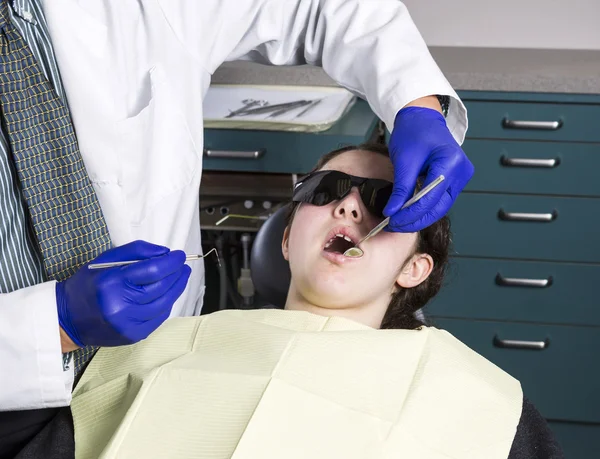 Dentist getting ready to do examination on teeth on young girl — Stock Photo, Image