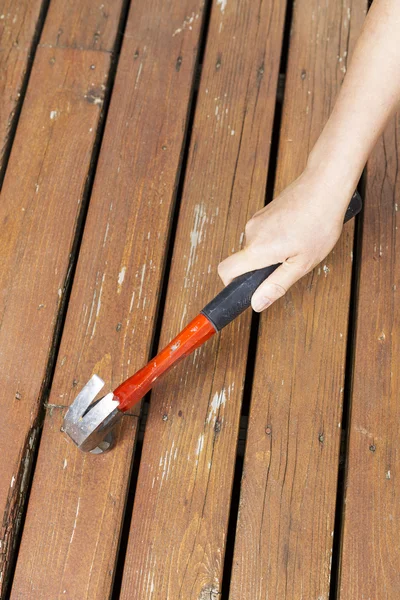 Weibliche Hand mit Hammer für Wartungsarbeiten auf Holzdeck — Stockfoto