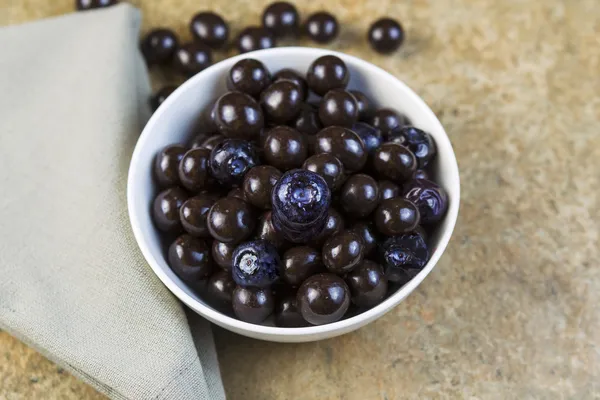 Skål fylld med blåbär och choklad bollar — Stockfoto