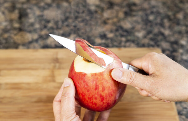 Fresh Apple being peeled with paring Knife