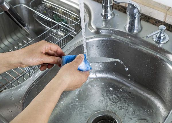 Mãos femininas lavar única faca pequena na pia da cozinha — Fotografia de Stock