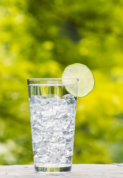 Vaso de agua y hielo con cal colocado al aire libre — Foto de Stock