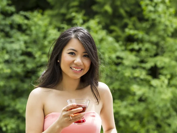 Joven mujer adulta sosteniendo una bebida afuera — Foto de Stock