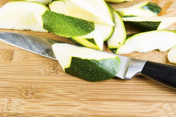 Zucchini-Scheiben auf Schneidbrett mit großem Messer — Stockfoto