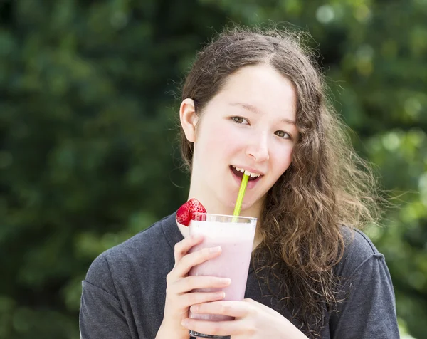 Щаслива молода дівчина п'є молочний коктейль на відкритому повітрі вдень — стокове фото
