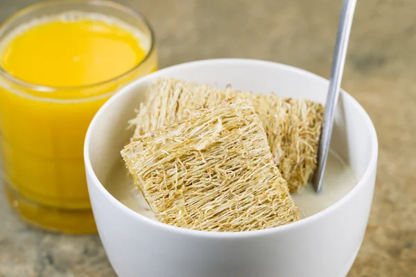 Whole grain cereal with honey and a glass of fresh orange juice — Stock Photo, Image