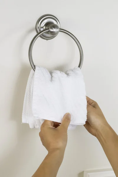 Les mains féminines mettent un chiffon de lavage propre sur le porte-serviette — Photo