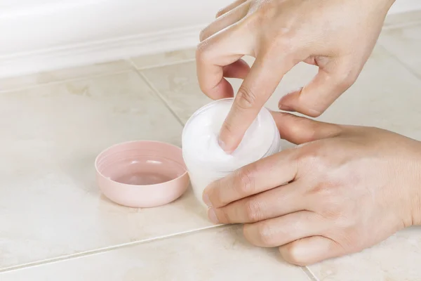 Front part of Female Index finger dipping into cosmetic cream — Stock Photo, Image