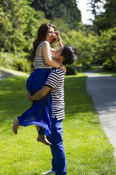 Jovem casal adulto brincando enquanto caminha ao ar livre — Fotografia de Stock
