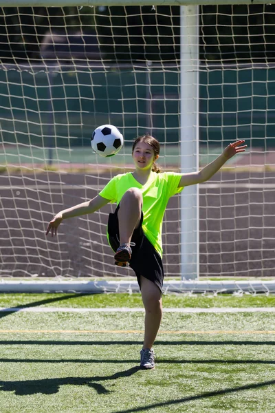 Chica joven concentrándose en la pelota de fútbol — Foto de Stock