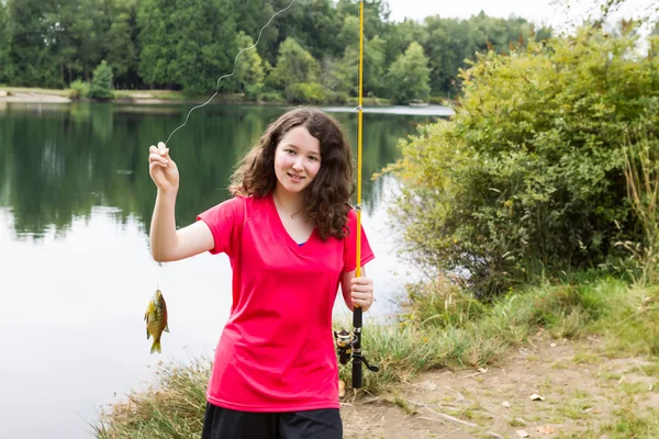 Девочка счастлива с уловом на озере — стоковое фото