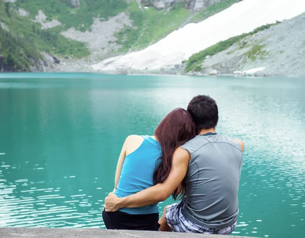 Jovens adultos amantes olhando para Pristine Aqua Mountain Lake — Fotografia de Stock