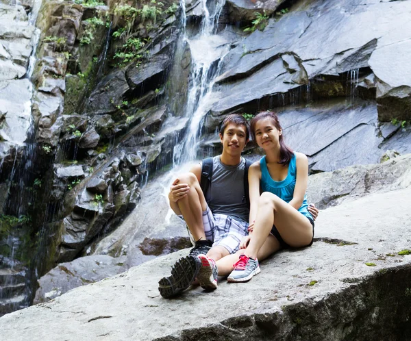 Giovani escursionisti attivi che riposano vicino alle cascate — Foto Stock