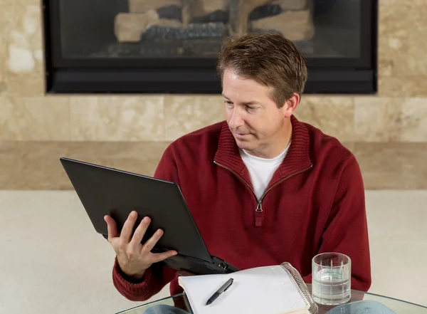 Dojrzały człowiek czytając informacje z jego komputera w domu — Zdjęcie stockowe