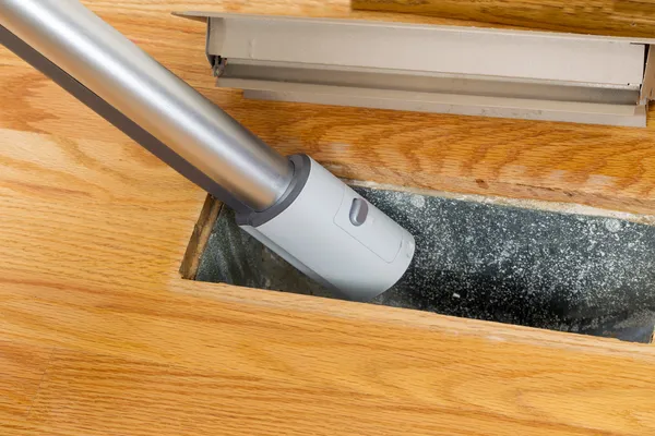 Прибирання всередині вентиляції підлоги за допомогою пилососа — стокове фото