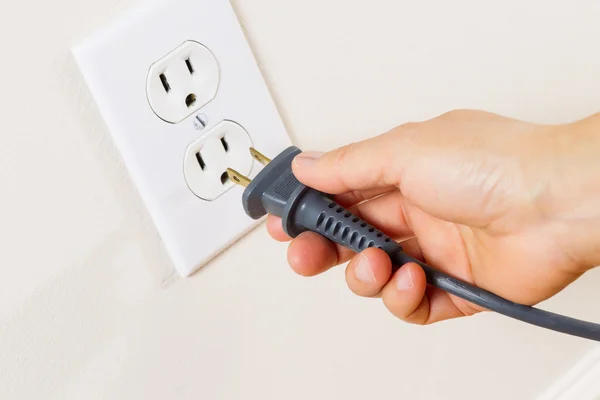 Inserting Power Cord Receptacle in wall outlet — Stock Photo, Image