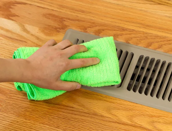 Placa de grelha de limpeza de mão de ventilação de aquecimento de piso em casa — Fotografia de Stock