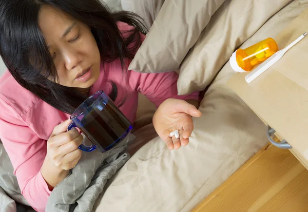 Volwassen vrouw innemen van medicijnen met thee — Stockfoto