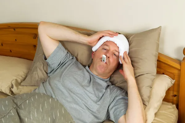 Больной мужчина с лихорадкой — стоковое фото