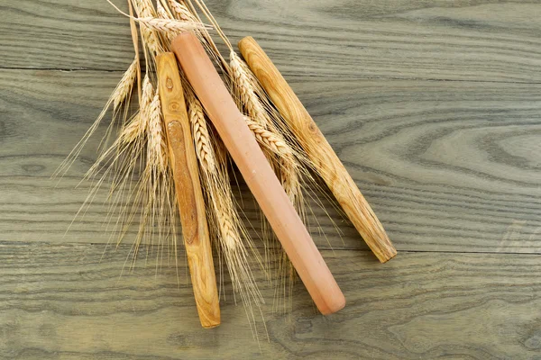 Holzbrötchen mit getrockneten Weizenstielen auf verblassendem Holz — Stockfoto