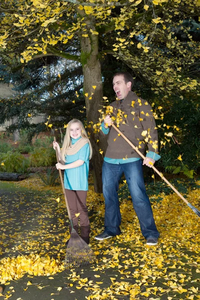 Папа и дочь не могут угнаться за падающими листьями. — стоковое фото