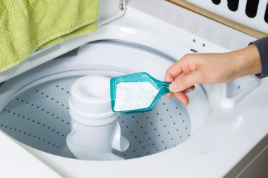Putting Soap into washing machine clipart
