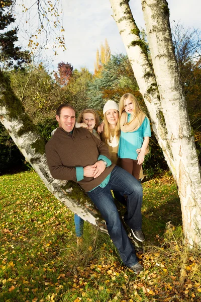 Glückliche Familie, die sich an einem schönen Tag im Herbst im Freien erholt — Stockfoto