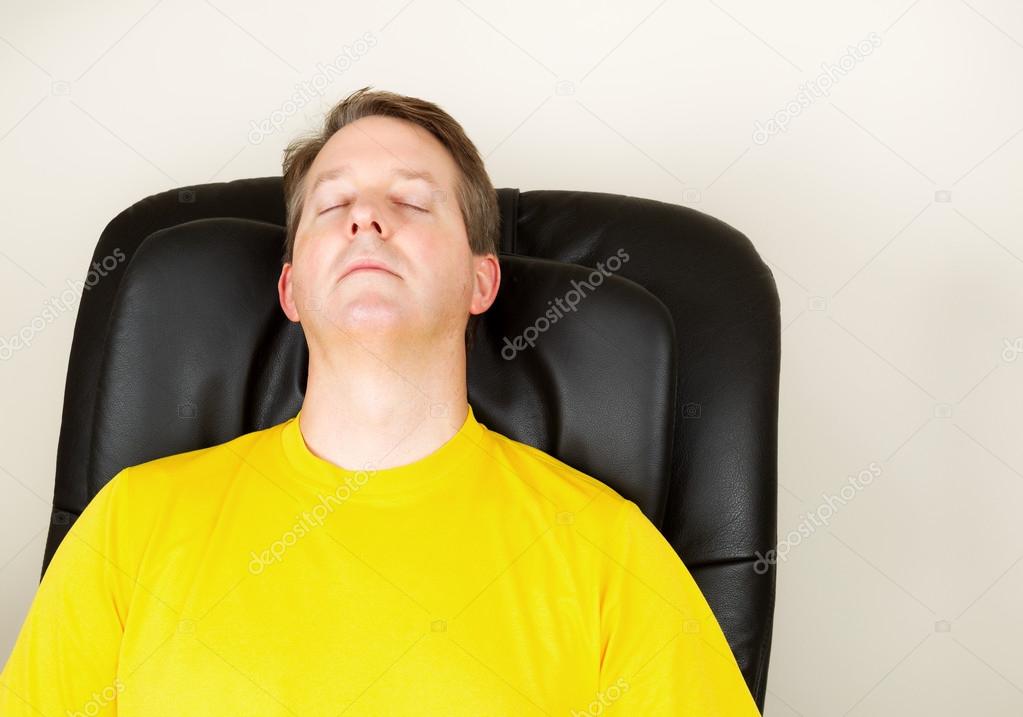 Mature Man Relaxing in Massage Chair